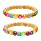 Gold bracelet with multicolored gemstones on a white background